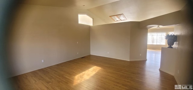 933 Julia Ln, Fernley, NV 89408 - spare room featuring arched walkways, vaulted ceiling, and wood finished floors