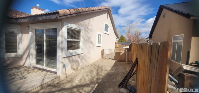 933 Julia Ln, Fernley, NV 89408 - view of property exterior featuring stucco siding, a tile roof, fence, and a chimney