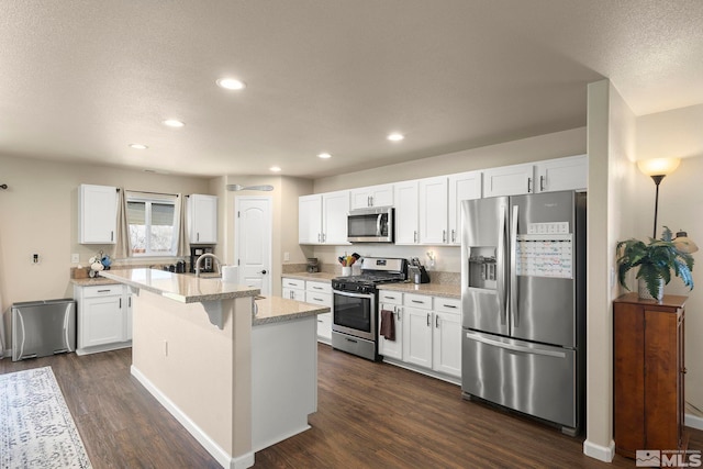 1953 Verona Dr, Fallon, NV 89406 - kitchen featuring stainless steel appliances, a kitchen island with sink, dark wood finished floors, white cabinets, and recessed lighting