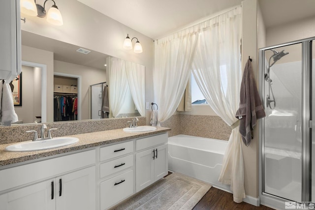 1953 Verona Dr, Fallon, NV 89406 - full bathroom with a shower stall, double vanity, a walk in closet, wood finished floors, and a bathtub