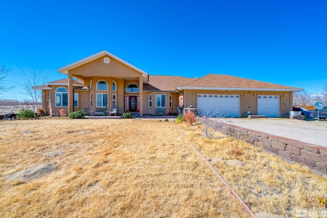 1253 Briggs Ln, Fallon, NV 89406 - view of front of property featuring stucco siding, an attached garage, driveway, and a porch