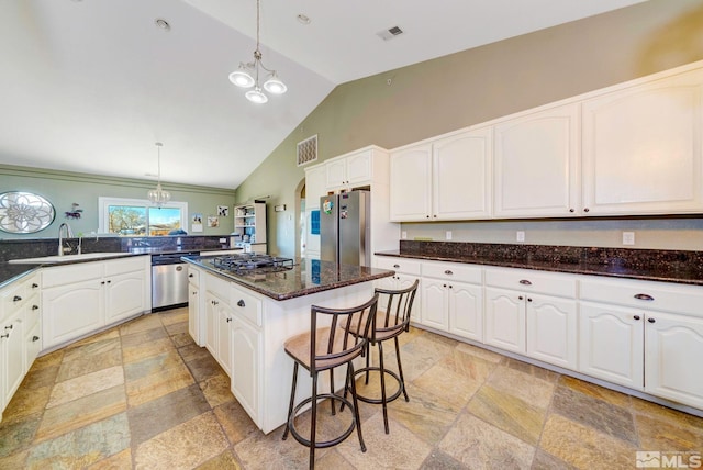 1253 Briggs Ln, Fallon, NV 89406 - kitchen featuring appliances with stainless steel finishes, stone tile flooring, a sink, a chandelier, and vaulted ceiling