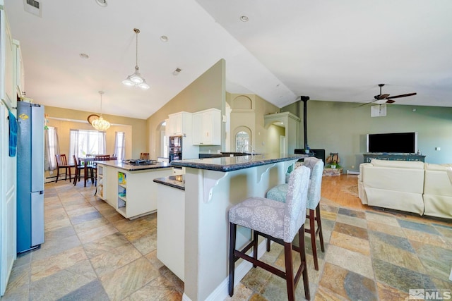 1253 Briggs Ln, Fallon, NV 89406 - kitchen with stone tile floors, ceiling fan, freestanding refrigerator, a kitchen island, and white cabinetry