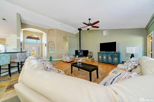 1253 Briggs Ln, Fallon, NV 89406 - living room with ceiling fan, arched walkways, lofted ceiling, a wood stove, and light wood finished floors