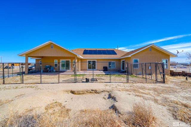 1253 Briggs Ln, Fallon, NV 89406 - view of front of house featuring solar panels, fence, stucco siding, and a patio