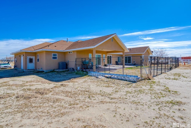 1253 Briggs Ln, Fallon, NV 89406 - rear view of property featuring stucco siding, central AC, fence, and a patio