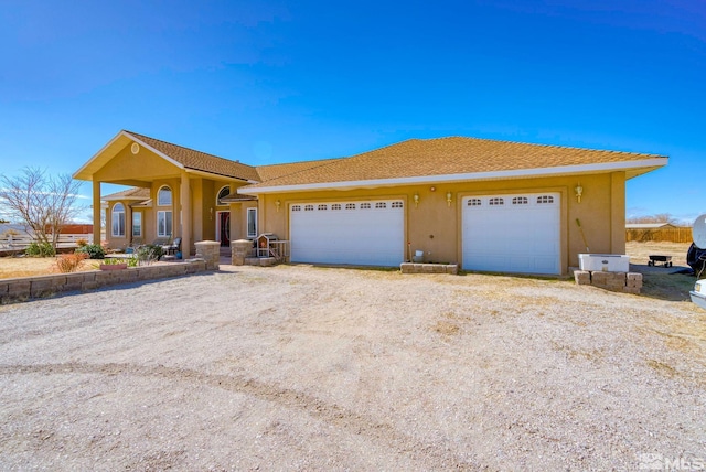 1253 Briggs Ln, Fallon, NV 89406 - view of front facade featuring dirt driveway, stucco siding, and an attached garage
