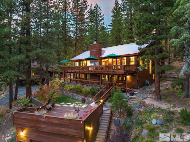 572 Rockrose Ct, Incline Village, NV 89451 - back of house at dusk featuring a chimney and a deck