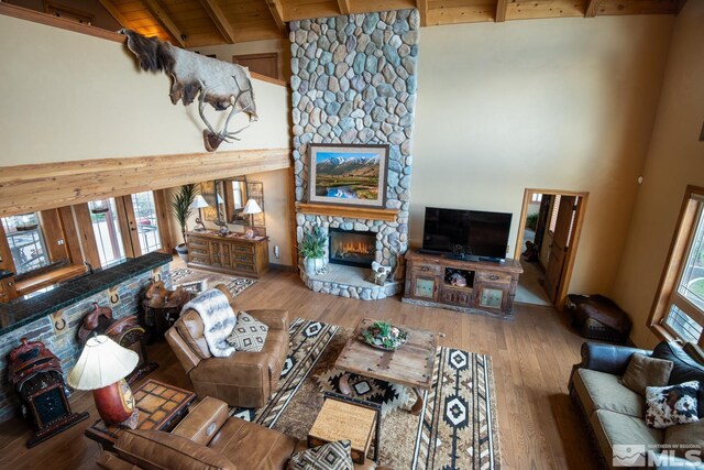 1101 Sierra Country Ct, Gardnerville, NV 89460 - living room featuring high vaulted ceiling, beam ceiling, a fireplace, wood finished floors, and wood ceiling