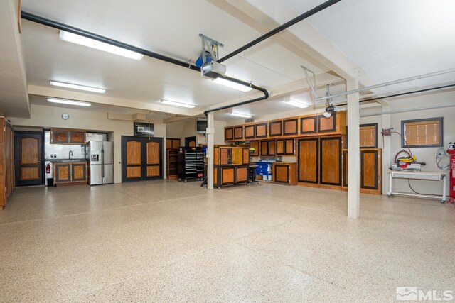 1101 Sierra Country Ct, Gardnerville, NV 89460 - garage with stainless steel fridge, a garage door opener, and a sink
