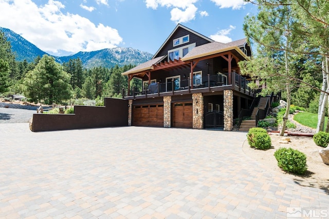 1101 Sierra Country Ct, Gardnerville, NV 89460 - view of front of property with a garage, stone siding, driveway, a mountain view, and a balcony
