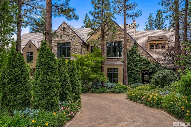 6025 Lake Geneva, Reno, NV 89511 - tudor house featuring stone siding, stucco siding, a chimney, and decorative driveway