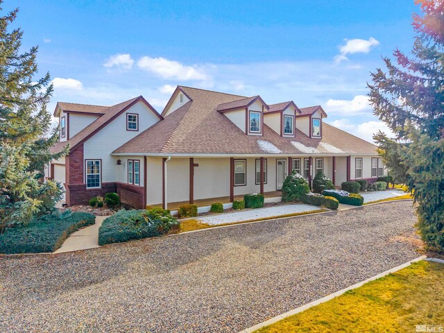 1973 Arabian Ln, Gardnerville, NV 89410 - view of front of house featuring brick siding, roof with shingles, and covered porch