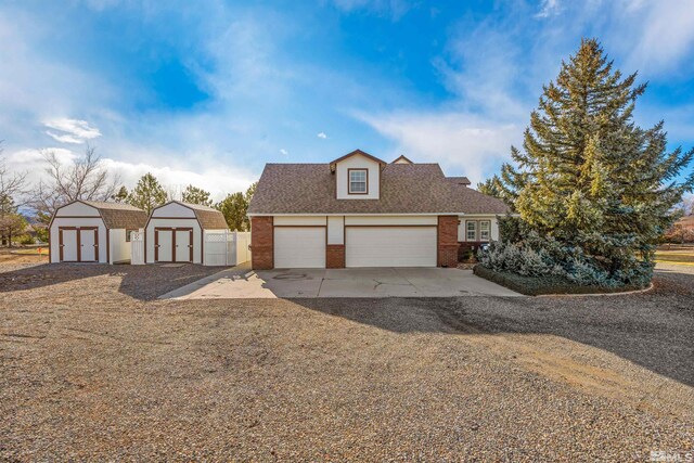 1973 Arabian Ln, Gardnerville, NV 89410 - traditional-style house with concrete driveway, a shed, brick siding, an outbuilding, and fence