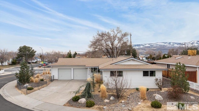 3230 Downey Ave, Reno, NV 89503 - single story home featuring concrete driveway, fence, a mountain view, and a garage