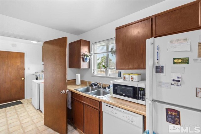 3230 Downey Ave, Reno, NV 89503 - kitchen featuring white appliances, a sink, washer and clothes dryer, and light countertops