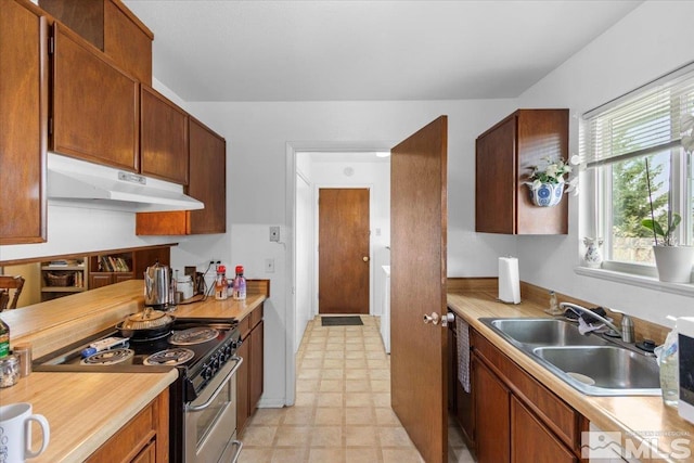 3230 Downey Ave, Reno, NV 89503 - kitchen with under cabinet range hood, stainless steel electric range, a sink, light countertops, and brown cabinets