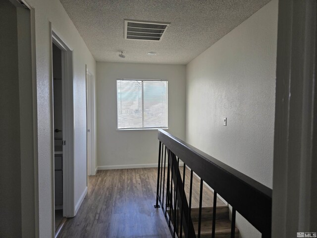 1023 Adrian Way, Sparks, NV 89431 - corridor with wood finished floors, a textured ceiling, an upstairs landing, baseboards, and a textured wall