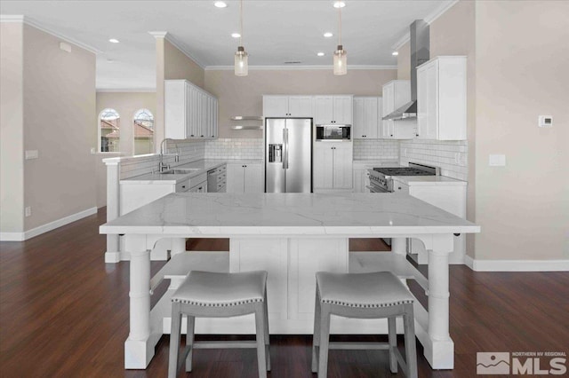 6141 Solstice Dr, Sparks, NV 89436 - kitchen with appliances with stainless steel finishes, wall chimney range hood, a sink, ornamental molding, and a breakfast bar area