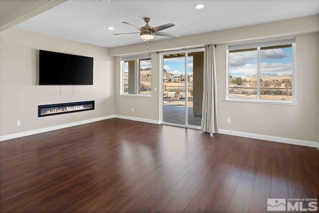 6141 Solstice Dr, Sparks, NV 89436 - unfurnished living room with a glass covered fireplace, a ceiling fan, baseboards, wood finished floors, and recessed lighting