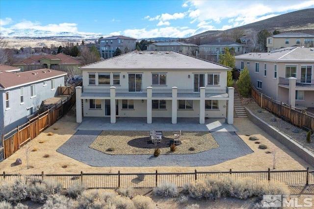 6141 Solstice Dr, Sparks, NV 89436 - back of house with a patio area, a residential view, stucco siding, and a fenced backyard