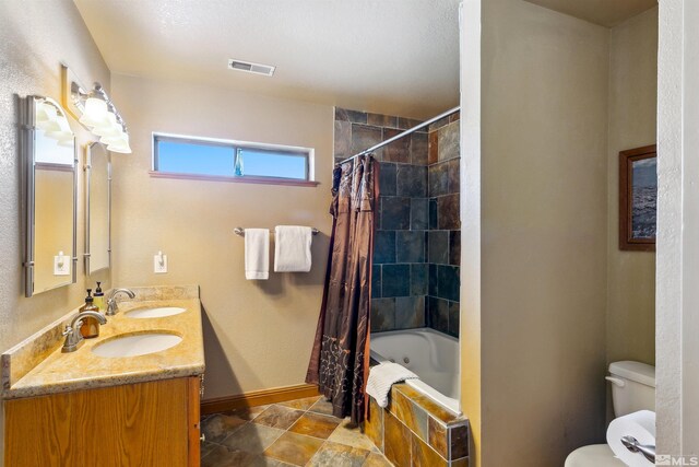 626 Canyon Dr, Zephyr Cove, NV 89448 - bathroom featuring toilet, baseboards, double vanity, and tiled shower / bath