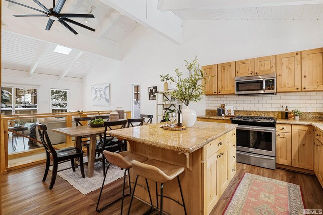 321 Ski Way Unit 29, Incline Village, NV 89451 - kitchen featuring appliances with stainless steel finishes, wood finished floors, beamed ceiling, decorative backsplash, and high vaulted ceiling