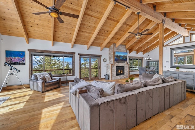 520 Laurel Ln, Stateline, NV 89449 - living area with a ceiling fan, light wood finished floors, beamed ceiling, wood ceiling, and a stone fireplace