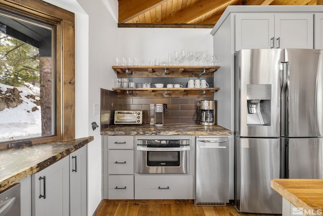 520 Laurel Ln, Stateline, NV 89449 - kitchen with appliances with stainless steel finishes, tasteful backsplash, white cabinetry, light wood finished floors, and dark stone counters