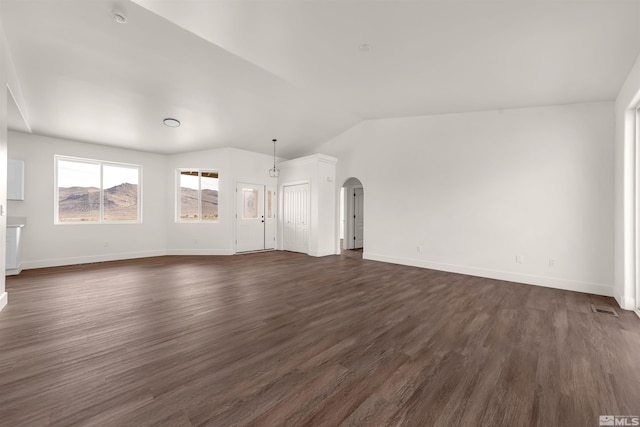 14485 N Red Rock Rd, Reno, NV 89508 - unfurnished living room featuring arched walkways, dark wood-style floors, baseboards, and lofted ceiling