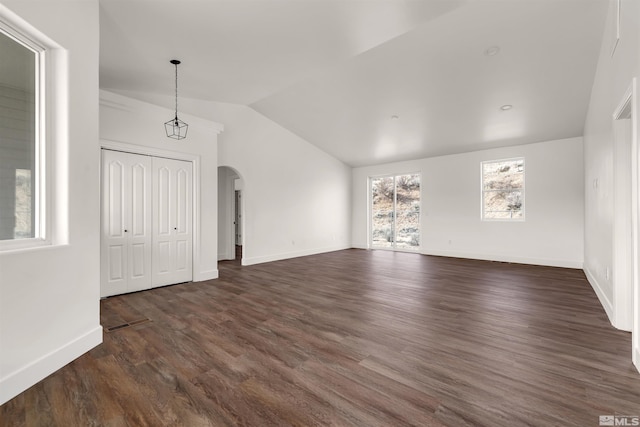 14485 N Red Rock Rd, Reno, NV 89508 - unfurnished living room with arched walkways, lofted ceiling, baseboards, and dark wood-style flooring