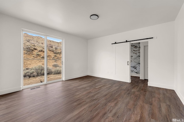14485 N Red Rock Rd, Reno, NV 89508 - spare room with dark wood-style flooring, a barn door, and baseboards