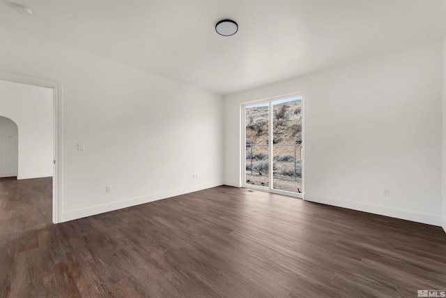 14485 N Red Rock Rd, Reno, NV 89508 - empty room featuring arched walkways, baseboards, and dark wood-style floors