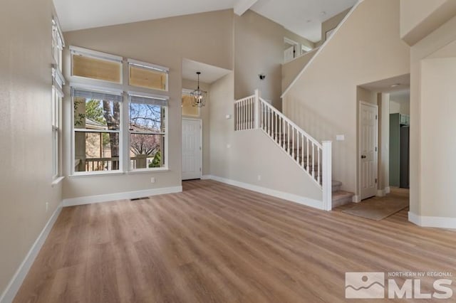 609 Caughlin, Reno, NV 89519 - unfurnished living room featuring stairs, wood finished floors, high vaulted ceiling, baseboards, and beamed ceiling