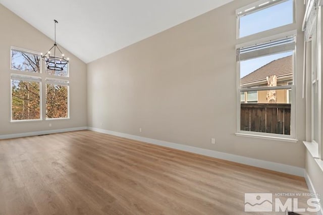 609 Caughlin, Reno, NV 89519 - unfurnished dining area featuring wood finished floors, a chandelier, baseboards, and high vaulted ceiling