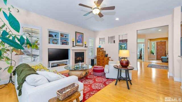 4940 Turning Leaf Way, Reno, NV 89519 - living room with healthy amount of natural light, wood finished floors, a warm lit fireplace, ceiling fan, and recessed lighting