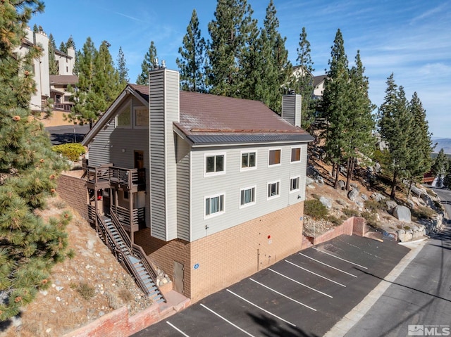 396 Tramway Dr # 3, Stateline, NV 89449 - view of home's exterior featuring a chimney, uncovered parking, stairs, and brick siding