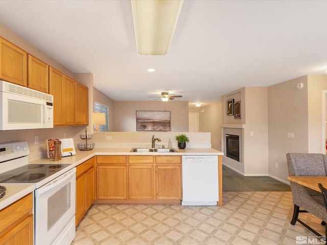7433 Gannon Dr, Reno, NV 89506 - kitchen with white appliances, a sink, light floors, a peninsula, and light countertops