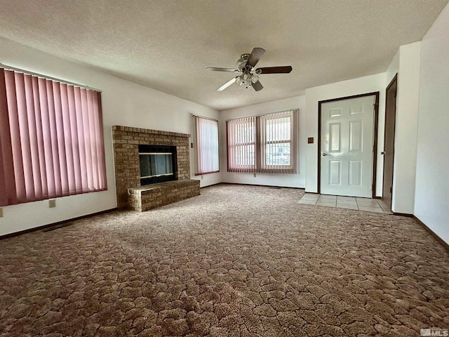 unfurnished living room with carpet, ceiling fan, baseboards, a textured ceiling, and a fireplace