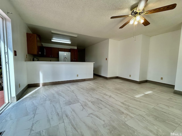 unfurnished living room with light marble finish flooring, a ceiling fan, a textured ceiling, and baseboards