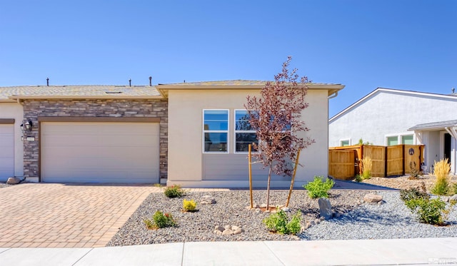 7317 Oakmont Ln, Sparks, NV 89436 - view of front of house featuring stone siding, fence, an attached garage, and stucco siding
