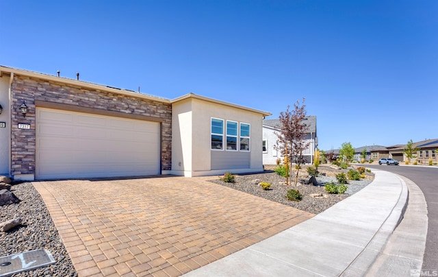 7317 Oakmont Ln, Sparks, NV 89436 - view of front of home with stucco siding, decorative driveway, stone siding, and an attached garage