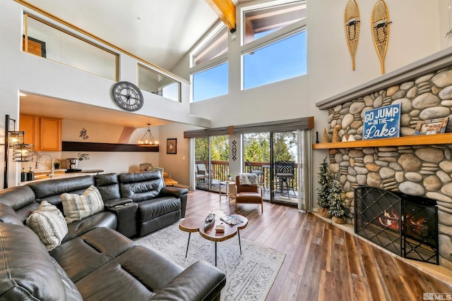 400 Fairview Blvd Unit 217, Incline Village, NV 89451 - living room featuring a chandelier, beam ceiling, wood-type flooring, high vaulted ceiling, and a stone fireplace