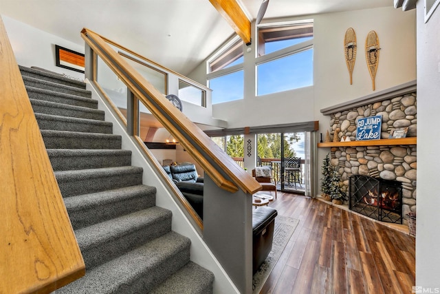 400 Fairview Blvd Unit 217, Incline Village, NV 89451 - staircase featuring hardwood / wood-style floors, beamed ceiling, a stone fireplace, and high vaulted ceiling