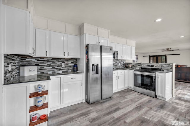 285 James Ave, Dayton, NV 89403 - kitchen with appliances with stainless steel finishes, a peninsula, white cabinetry, light wood-type flooring, and dark countertops