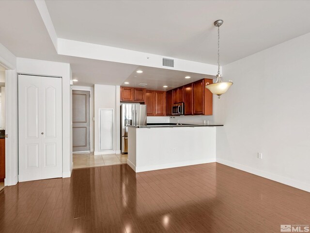 50 N Sierra Unit 605, Reno, NV 89501 - kitchen with appliances with stainless steel finishes, dark countertops, pendant lighting, light wood-style floors, and recessed lighting