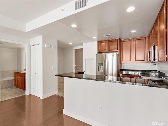 50 N Sierra Unit 605, Reno, NV 89501 - kitchen featuring stainless steel appliances, recessed lighting, dark countertops, and brown cabinetry