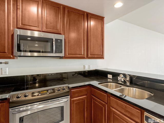 50 N Sierra Unit 605, Reno, NV 89501 - kitchen with appliances with stainless steel finishes, a sink, dark countertops, brown cabinetry, and recessed lighting