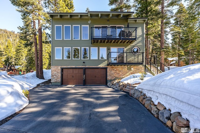 1005 Marlene St, Incline Village, NV 89451 - back of property with a balcony, a garage, asphalt driveway, stone siding, and stairway