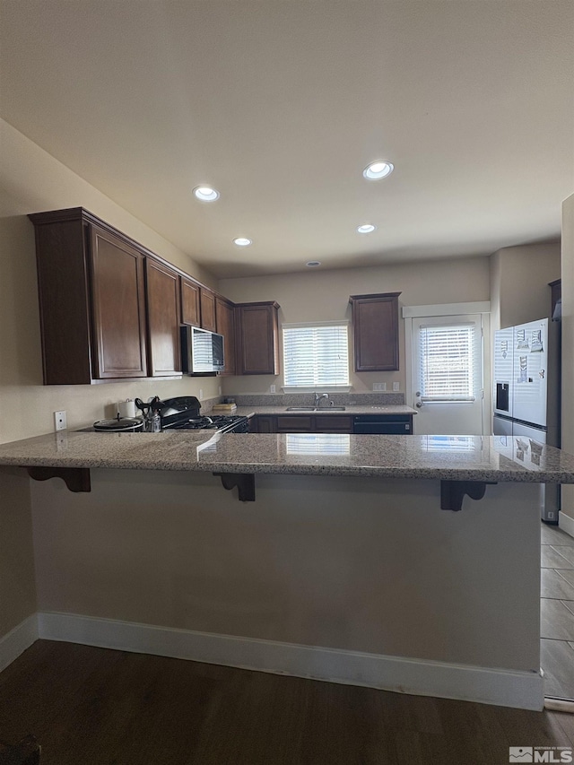 5282 Western Way, Winnemucca, NV 89445 - kitchen featuring black gas range oven, a peninsula, a kitchen bar, and recessed lighting